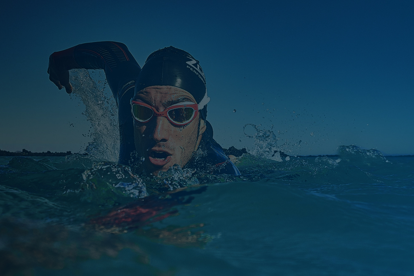 Participants running into the water for start of a triathlon Tri